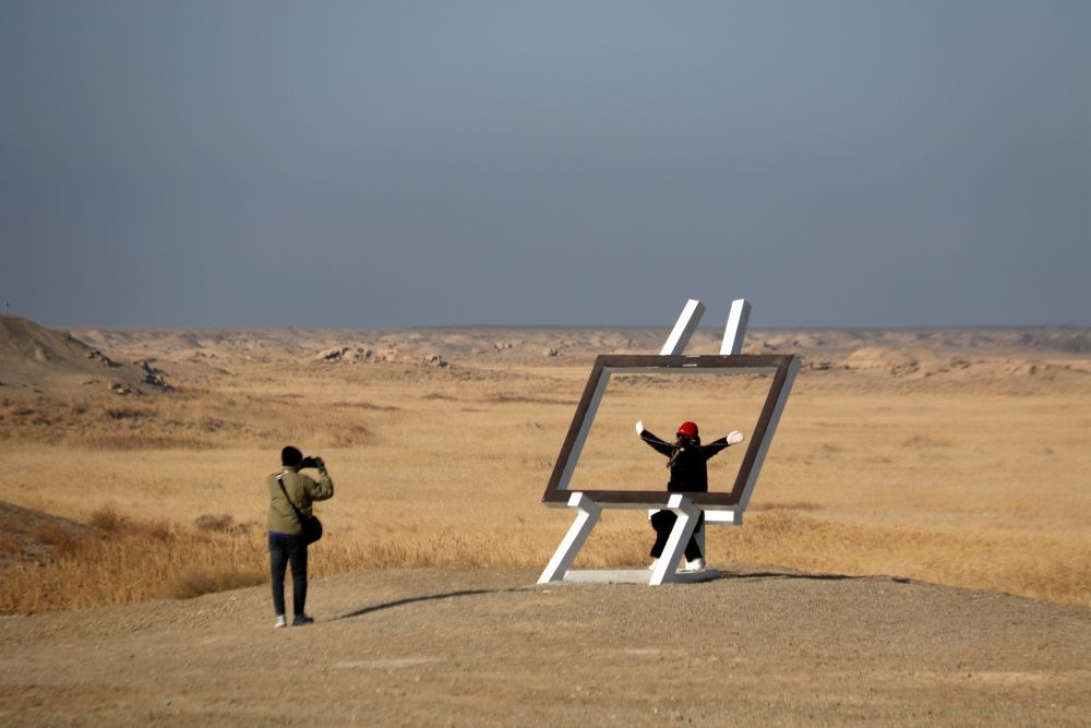 2024年12月14日，游客在甘肃省敦煌市玉门关景区汉长城遗址参观。张晓亮　摄
