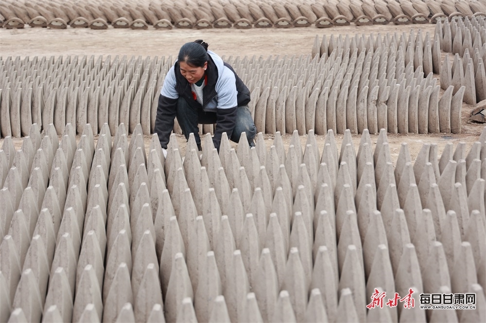 12月8日,在陇南市康县太石乡雍坝村,村民们正在用传统工艺制作铸铧模具。