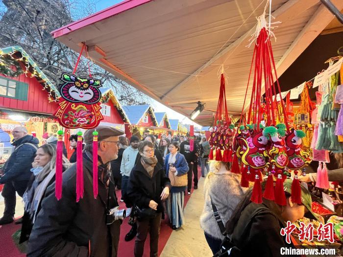 近日，在法国巴黎埃菲尔铁塔下的圣诞集市，来自中国甘肃省庆阳市的“庆阳香包”获得法国当地民众的赞美。董春阳　摄