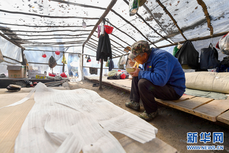 这是在林子里为临时歇脚而搭建的工棚，护林员在工棚内就餐。