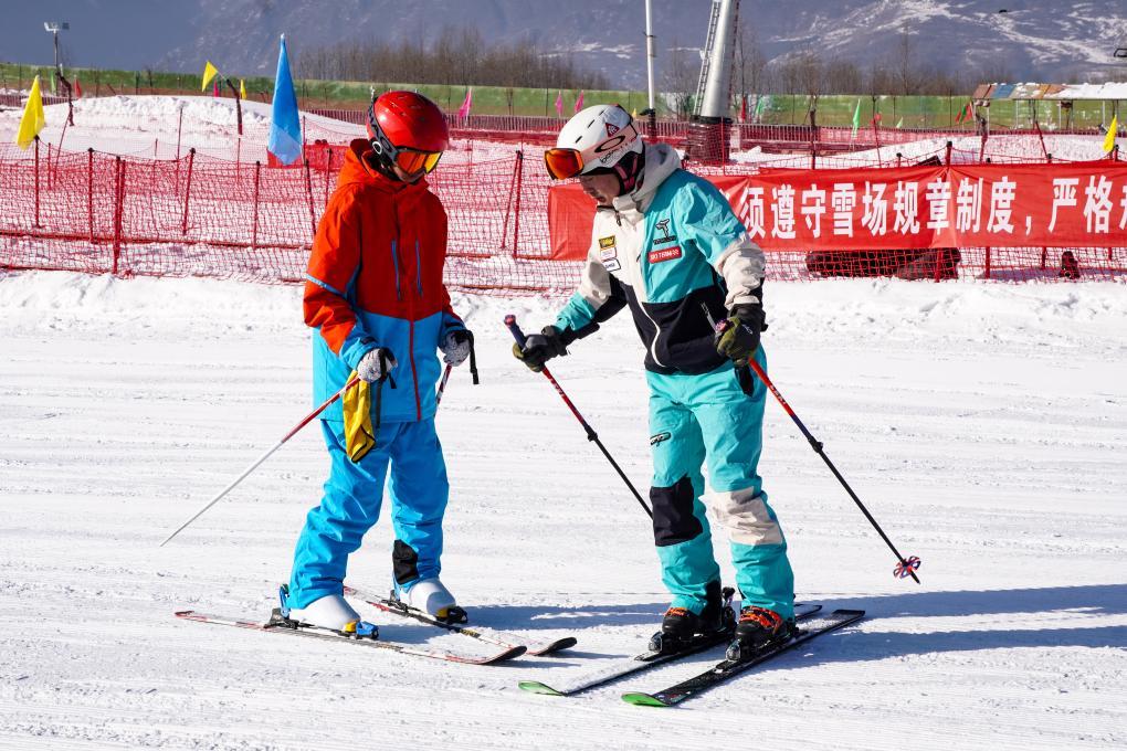 12月19日,在松鸣岩国际滑雪场,滑雪教练正在向学员教授滑雪技巧。新华社记者 王俊杰 摄