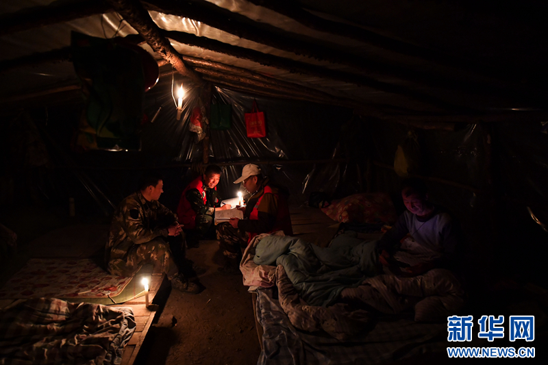 远山巡护无法当天返回管理站时，护林员就住在林区的工棚里。他们借着烛光将当天的巡护情况记录下来，再计划一下第二天的行程。