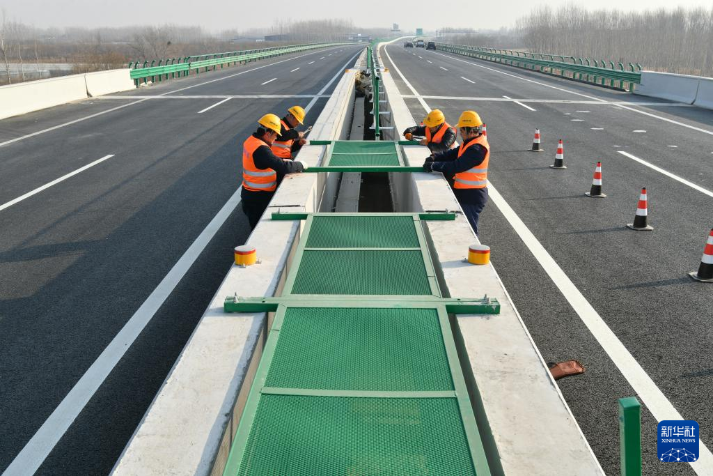 12月20日,中铁八局集团工人在曲港高速沧州段七标段工地安装护栏。