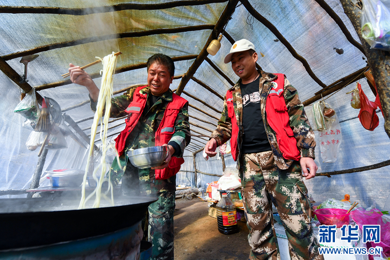 临近中午时分，郝永全（左）和李亚飞在工棚内煮面条。