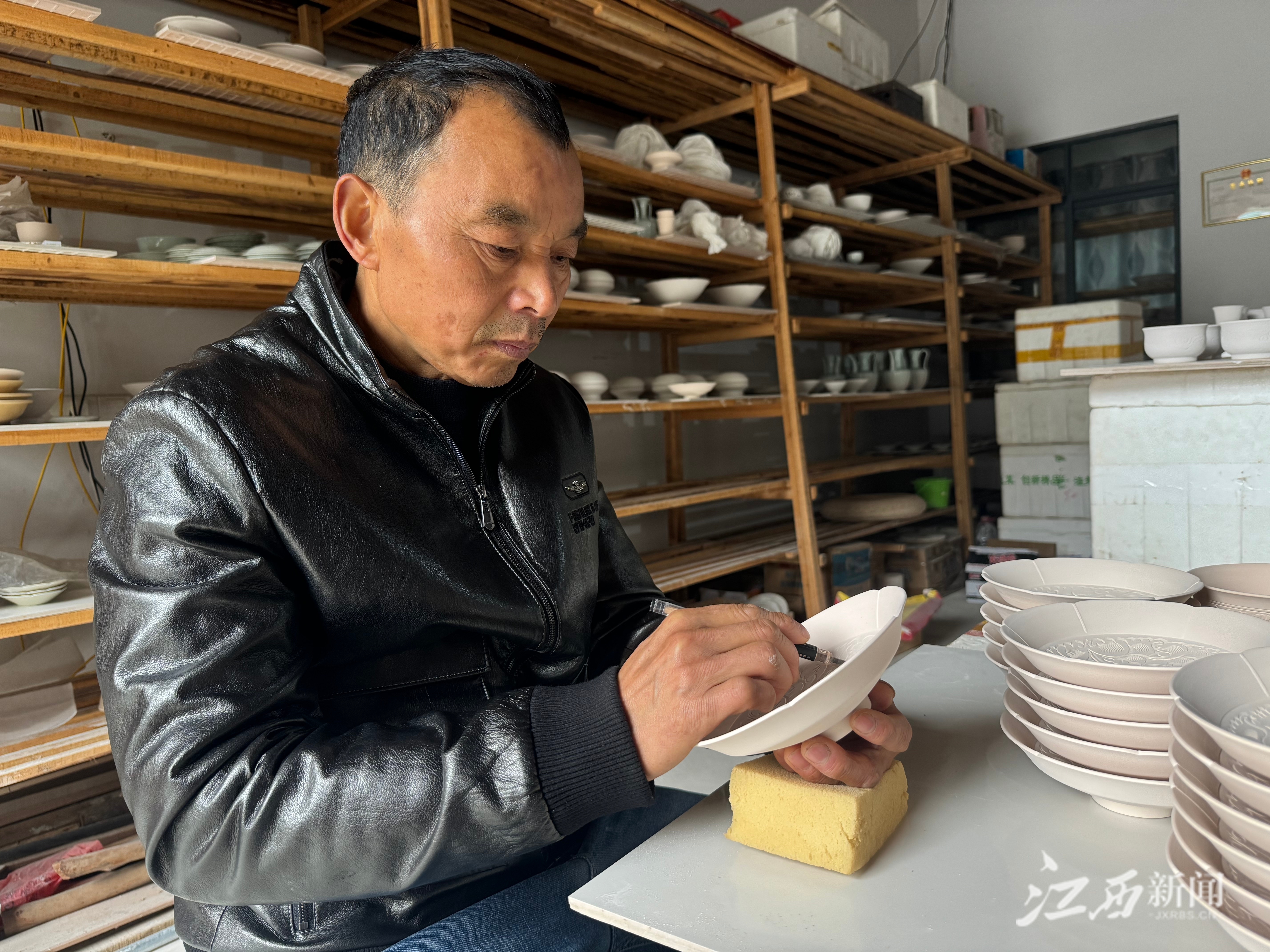 ▲土生土长于南市街的景德镇青白瓷市级非遗传承人姚金林，研究古瓷碎片，复原古法制瓷技艺。