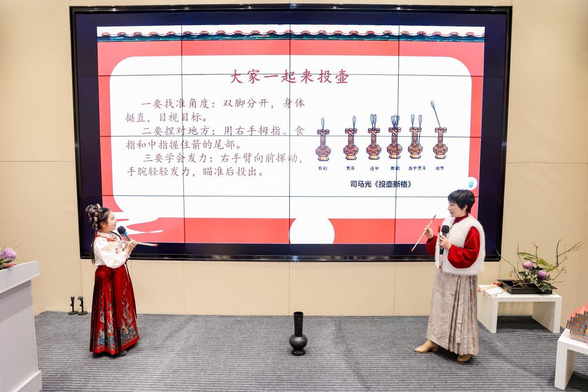 丛书作者和学生代表示范中国传统小游戏“投壶”技巧