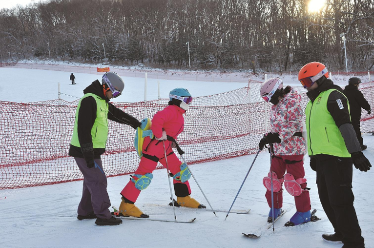 在鸣山绿洲滑雪场里，教练员在细心地教导学员。