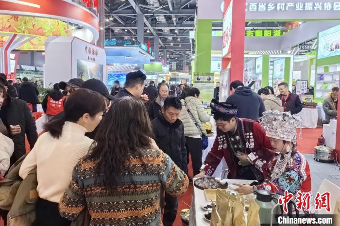 1月3日,第六届江西“生态鄱阳湖·绿色农产品”博览会暨江西电商年货节在南昌开幕。图为湖南展商刘修鹏和同事正接待客人。吴鹏泉 摄