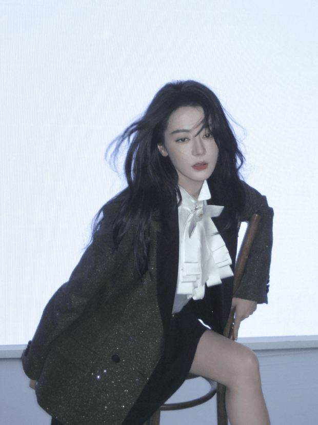 迪丽热巴发丝随风飘动，神态冷艳舒展。