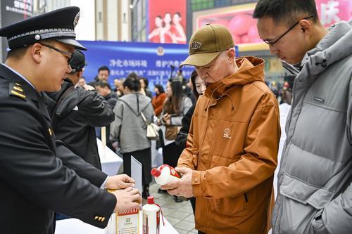 活动现场，工作人员向市民介绍如何分辨假酒。记者 齐岚森 摄