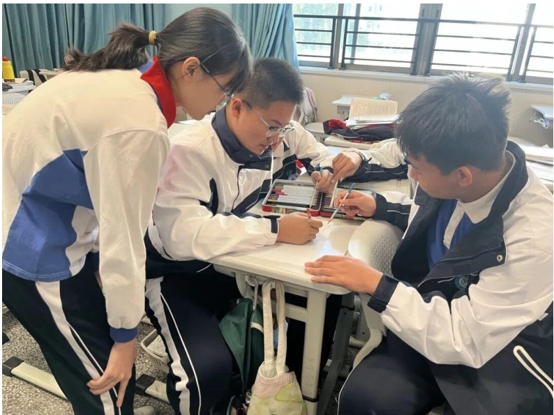 学生小组讨论选择心仪的"中国星火"人物,从航天科学家到基层建设者,从艺术名家到深圳本土模范