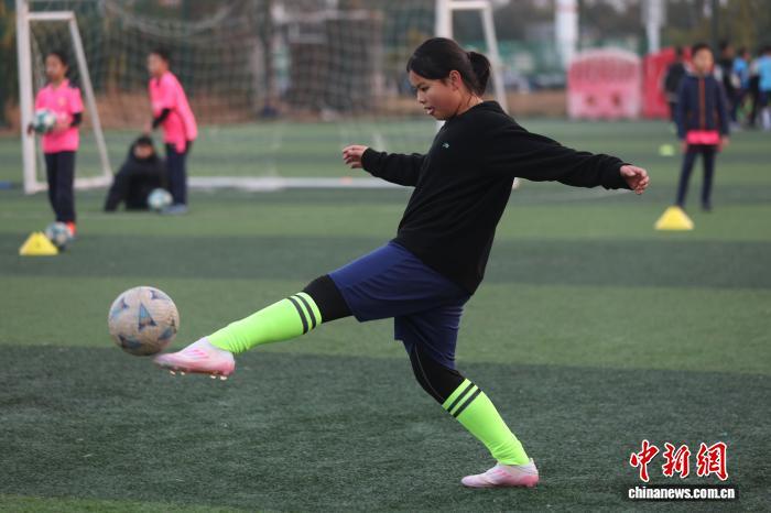 图为一名女孩正在练习射门。中新社记者 刘占昆 摄