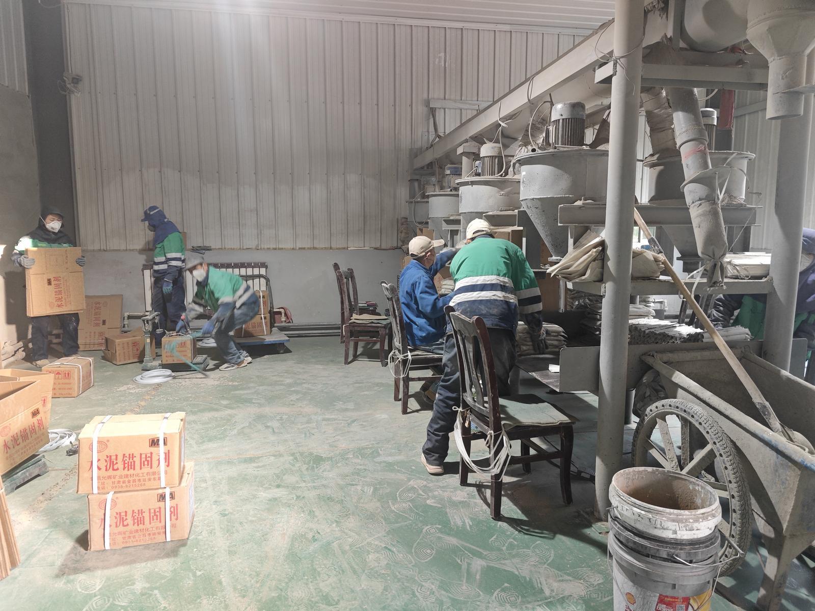 △灌装工位上，听障职工正在进行水泥锚固剂的装袋和搬运工作。