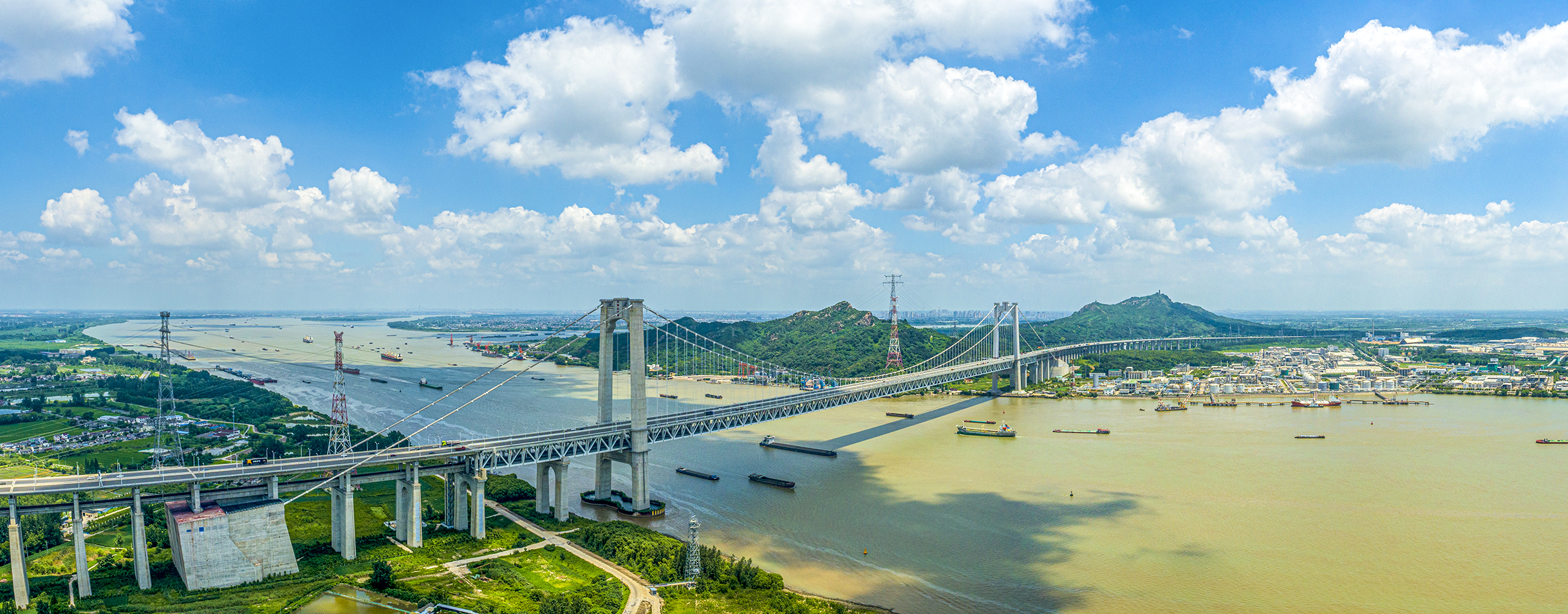 复兴号驶过五峰山大桥0--建成时创下7项世界纪录的五峰山长江大桥,宽阔的长江水道上,地处镇江境内的五峰山长江大桥同时吐纳高铁、汽车、大型货轮等不同交通工具,勾勒出一幅充满活力的立体图景。