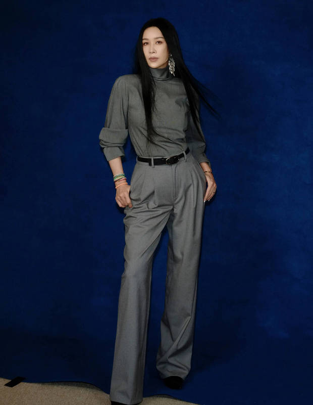 搜狐娱乐讯 28日，那英最新拍摄的写真大片释出，她一身灰色Look显优雅成熟，戴超大耳饰时髦吸睛，长发及腰超有范儿。