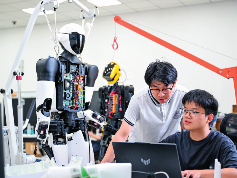 在位于湖北省武汉市的华中科技大学机械科学与工程学院,研究人员对“荆楚”人形机器人进行代码调试(2025年5月29日摄) 杜子璇摄/本刊