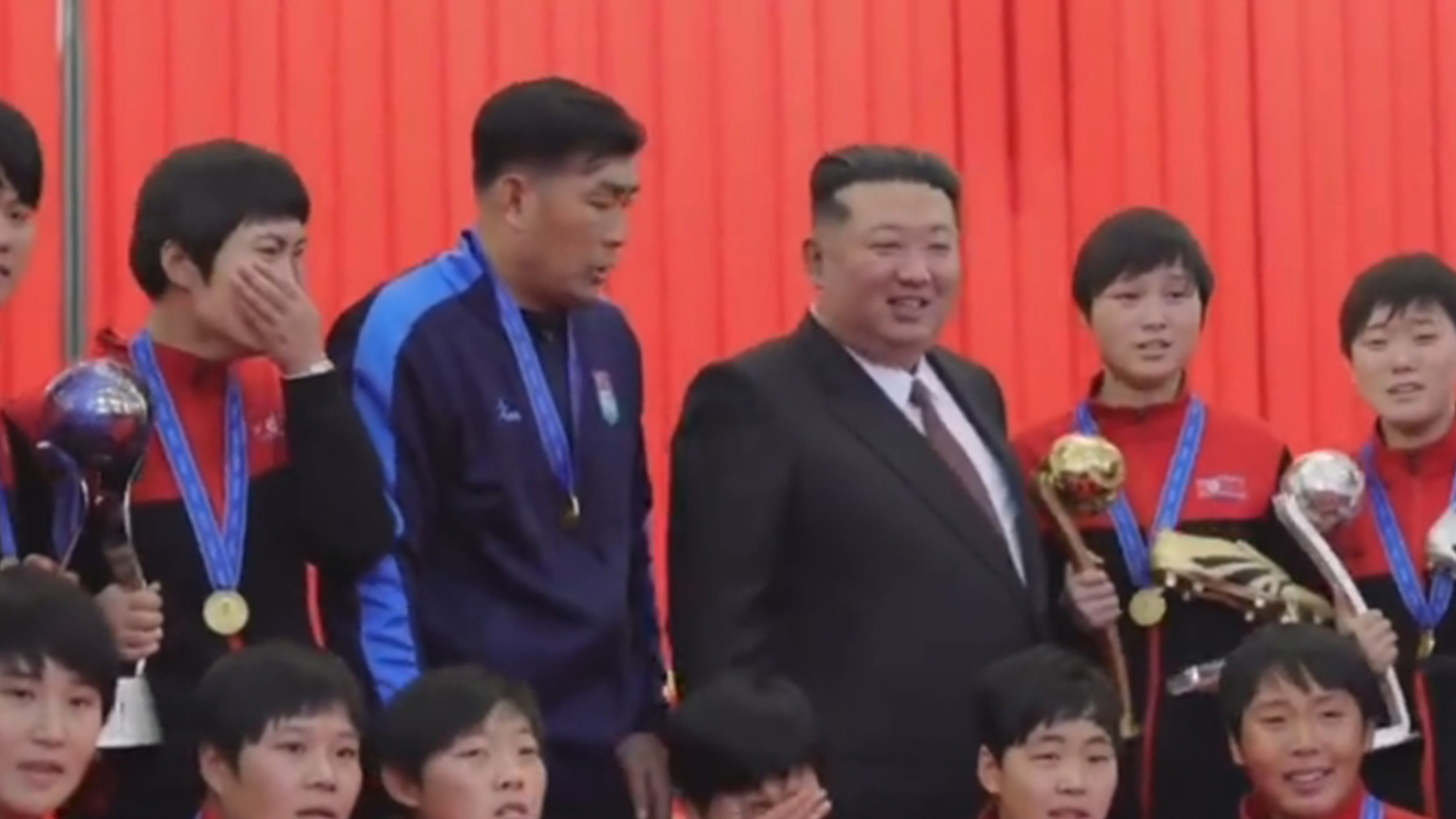 现场掌声雷动经久不息！金正恩手握红旗宣誓，接见朝鲜劳模和女足冠军队，姑娘们热泪盈眶 争相簇拥