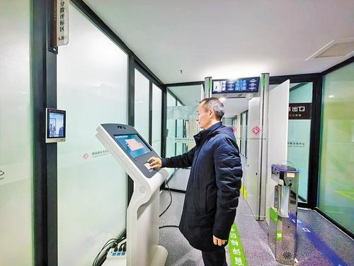 12月25日，评标专家在唐山市公共资源交易中心评标区签到机前，自助核验身份开启门禁。 本报记者王育民摄