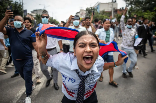 ▎2025日,一名示威者在尼泊尔议会大楼外高呼口号,抗议政府的社交媒体禁令及腐败问题。图源:法新社