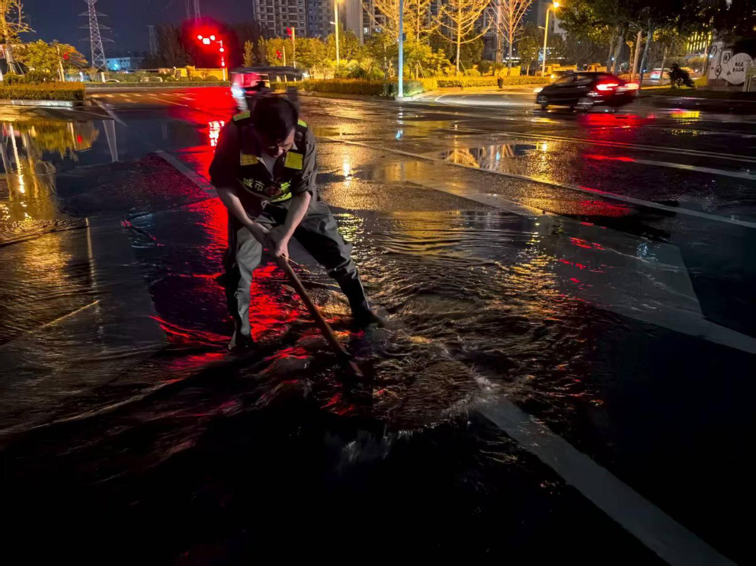 市政人員雨中恢復積水路段窨井