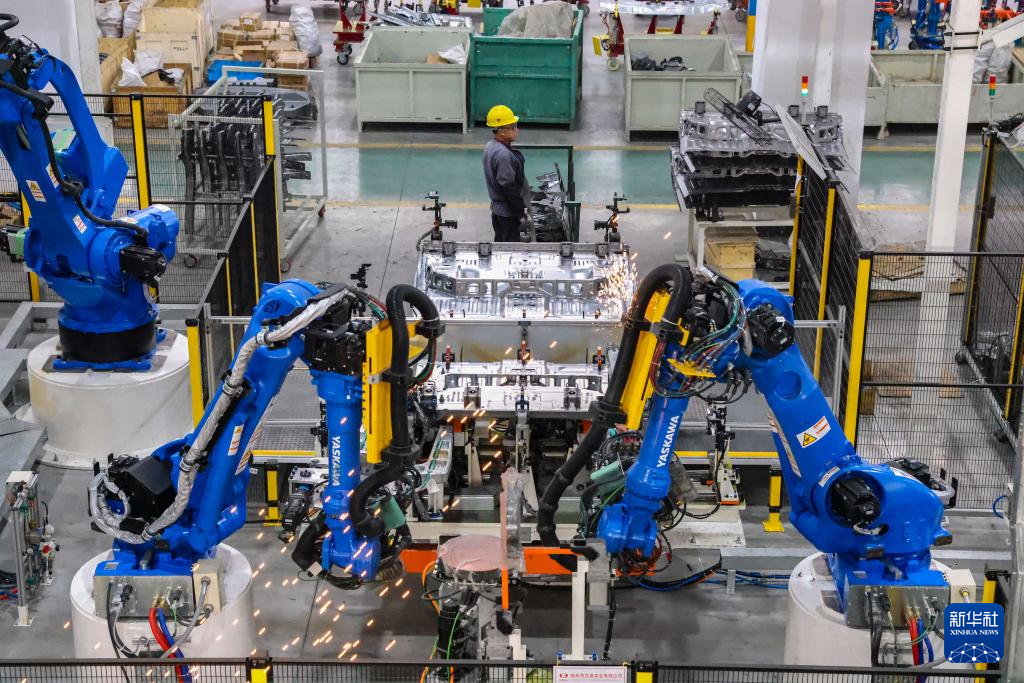 1月3日，在江苏省江都高新技术产业开发区扬州市洪泉实业有限公司智能生产车间，工业机器人在生产线上作业。新华社发（任飞摄）