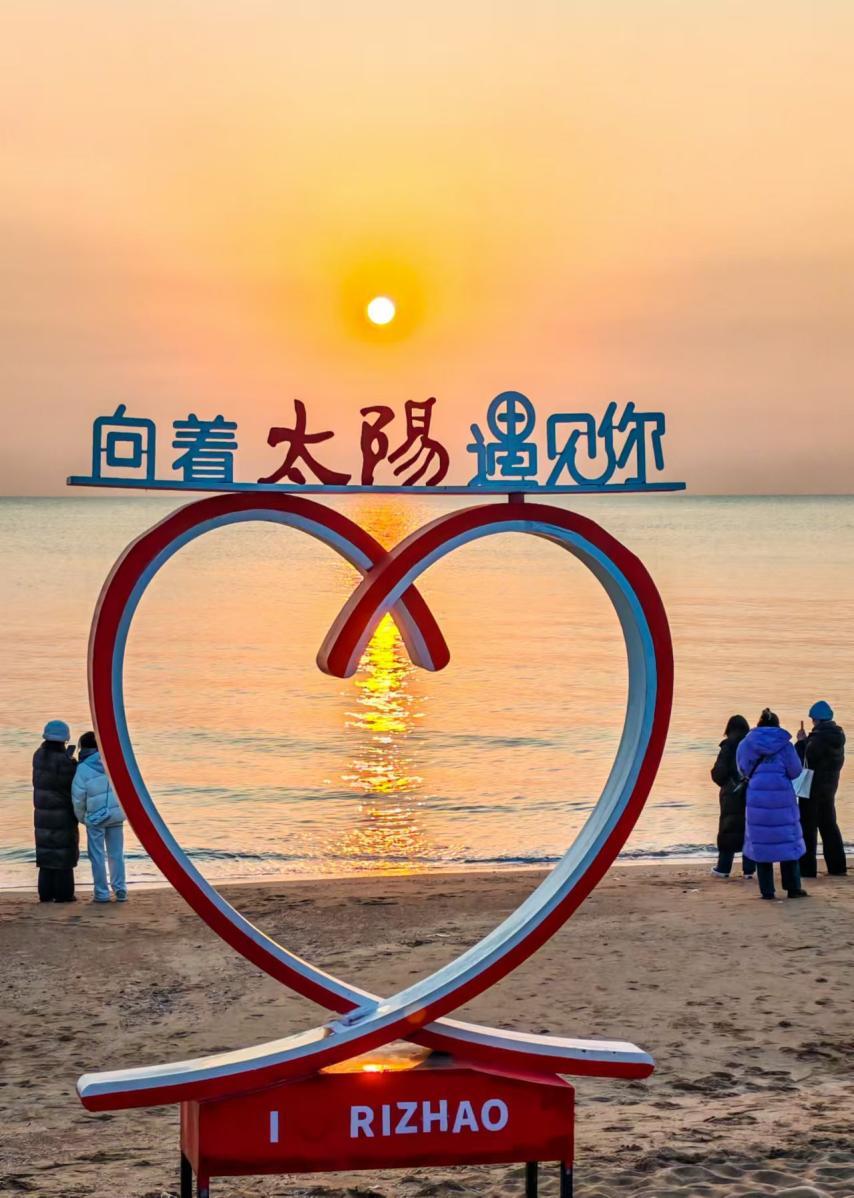 太阳的光芒强势穿透云层，倾洒在海面上，市民游客们纷纷迅速掏出手机，留存下此刻的美好。叶连俊 摄