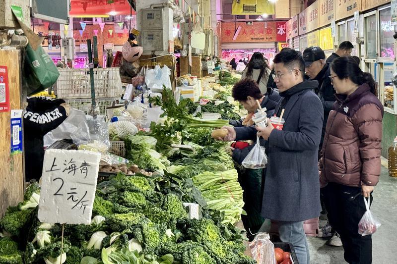 市民在老菜场市井文化创意街区内的建国门综合市场选购新鲜蔬菜。