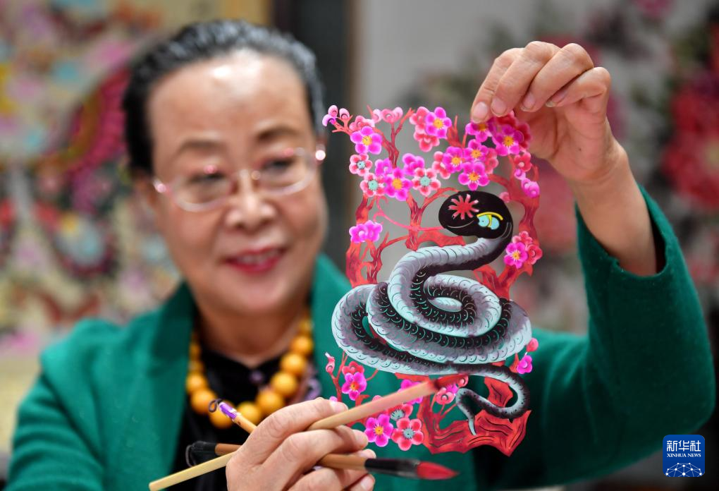 1月3日,蔚县剪纸国家级代表性传承人周淑英在河北省石家庄市新华区名家工作室展示生肖蛇作品。