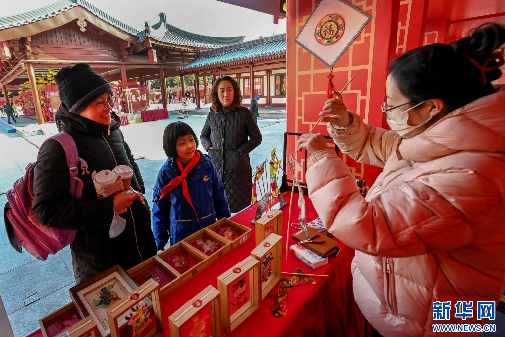 1月8日,市民在西安大唐芙蓉园内的非遗年货集市上选购汪氏皮影文创产品。