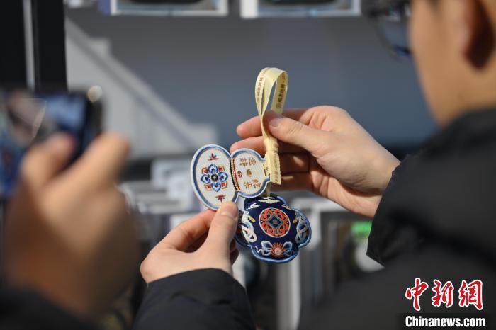 1月10日，在甘肃省敦煌市敦煌博物馆内，游客挑选“蛇”元素文创产品。随着农历乙巳蛇年临近，敦煌博物馆内具有敦煌文化的“蛇”元素文创产品渐热。中新社记者　李亚龙　摄