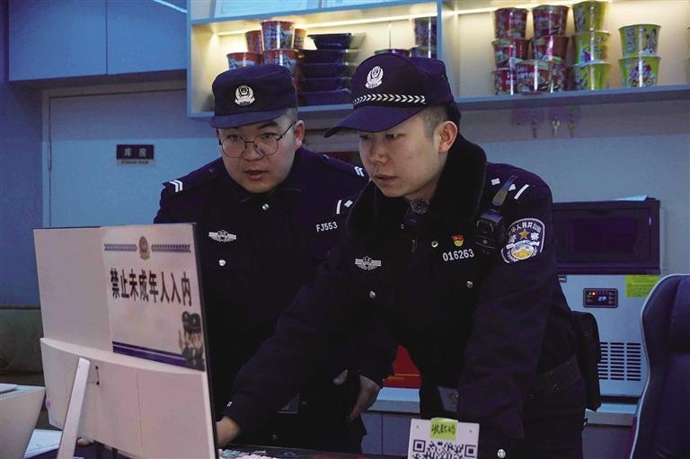 冯宇晨（右）和同事检查辖区网吧人员信息