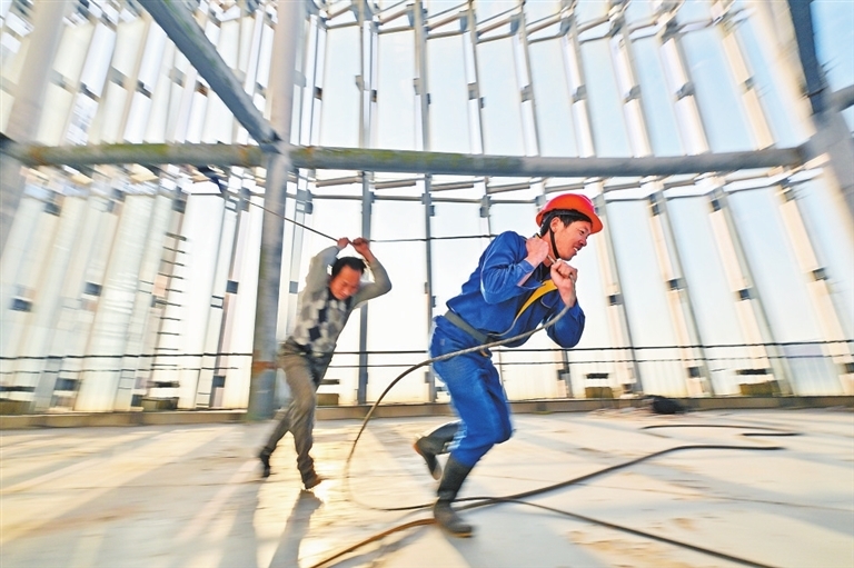 工人们在完成幕墙清洗工作后，收回绳索。