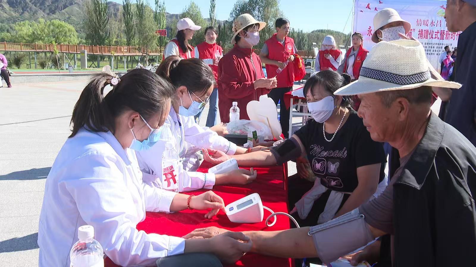 医务志愿者现场为居民量血压、测血糖等