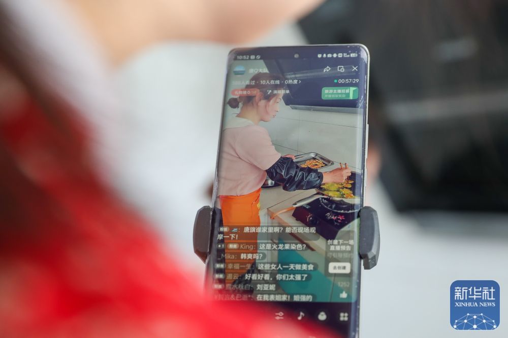 1月5日,“唐Q大队”助农工作室主播在庆阳市合水县西华池镇唐旗村村民家里直播特色小吃“炸油果果”的制作过程。