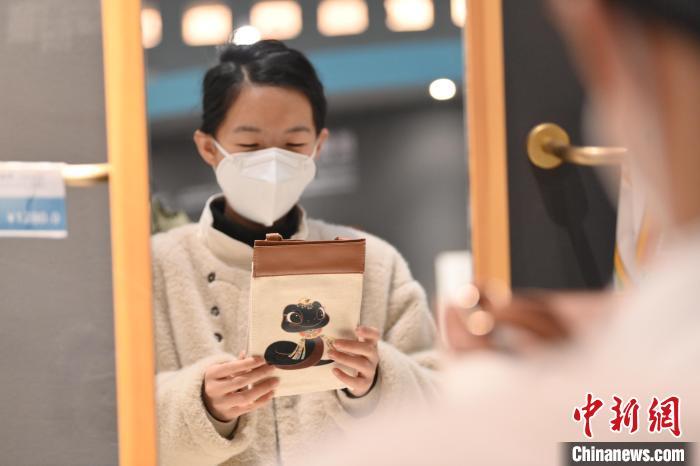 1月10日，在甘肃省敦煌市敦煌博物馆内，游客挑选“蛇”元素文创产品。随着农历乙巳蛇年临近，敦煌博物馆内具有敦煌文化的“蛇”元素文创产品渐热。中新社记者　李亚龙　摄