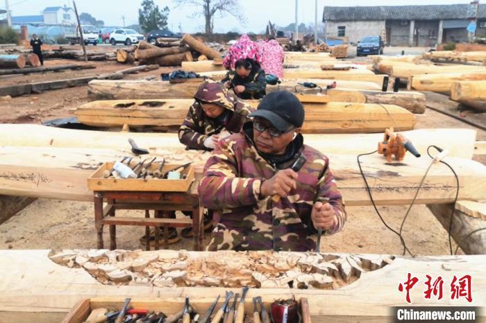 2024年12月25日，在江西都昌县南峰镇一处古建筑修复基地，工匠们熟练地操持着各种工具挥斧刨料、锯榫凿眼。江建峰 摄