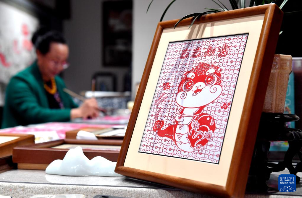 1月3日,蔚县剪纸国家级代表性传承人周淑英在河北省石家庄市新华区名家工作室制作生肖蛇作品。