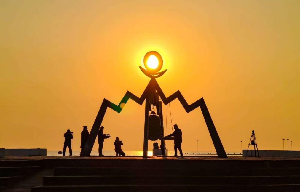 伴随着太阳的升起，游客敲响清晨的响钟。叶连俊 摄