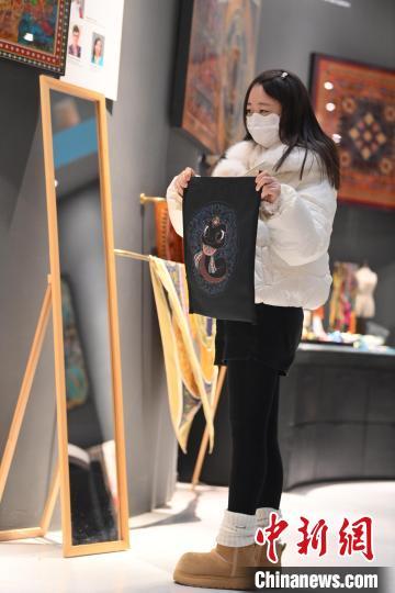 1月10日，在甘肃省敦煌市敦煌博物馆内，游客挑选“蛇”元素文创产品。随着农历乙巳蛇年临近，敦煌博物馆内具有敦煌文化的“蛇”元素文创产品渐热。中新社记者　李亚龙　摄