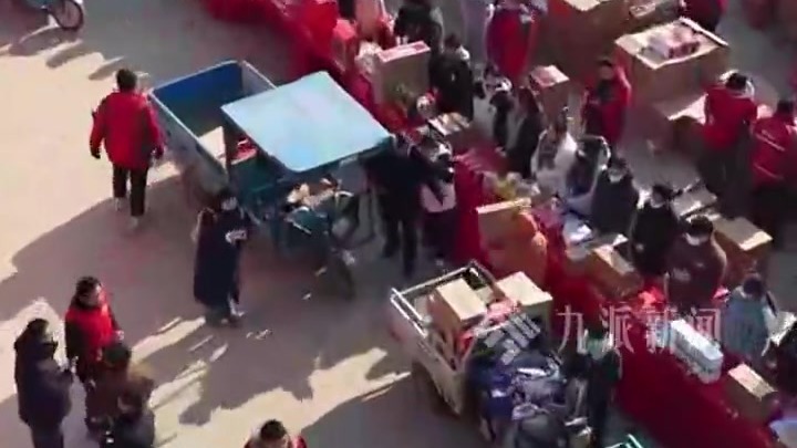 航拍刘强东给乡亲们发年货现场：三轮车排队领物资，有警察在现场维持秩序
