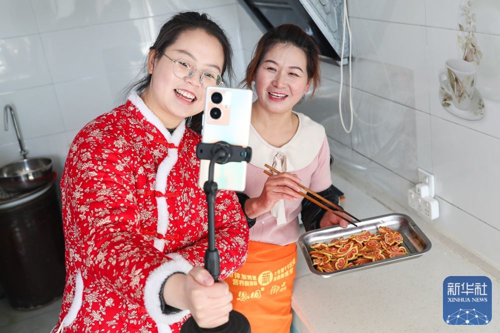 1月5日,“唐Q大队”助农工作室主播在庆阳市合水县西华池镇唐旗村村民家里直播特色小吃“炸油果果”的制作过程。