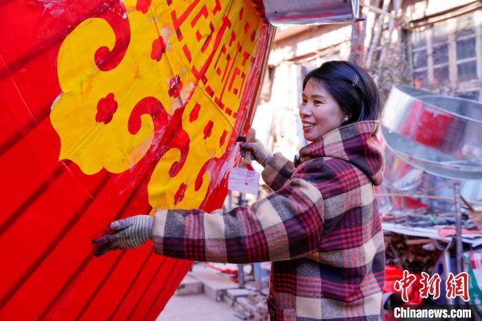 图为1月9日，村民在宫灯上帖云花。王朋 摄