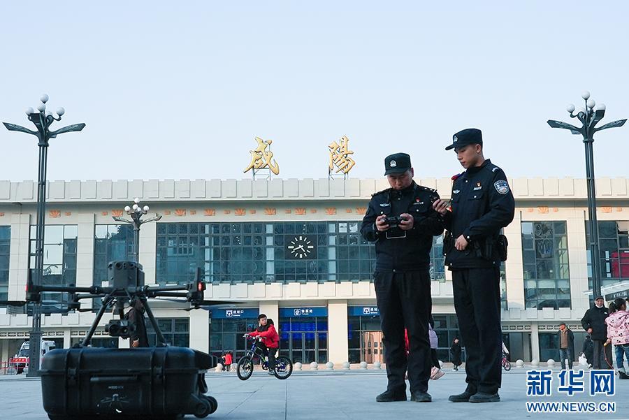 1月14日，2025年春运首日，在咸阳火车站，两位民警准备放飞警用无人机，对车站进行全视角巡视。新华网 杨喜龙 摄