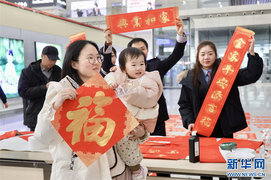 1月14日，在郑州东站候车室内举办的送春联活动现场。