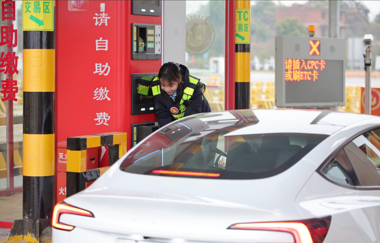 南昌西管理中心九龙湖收费站工作人员帮助司乘快速使用自助收费系统支付通行费