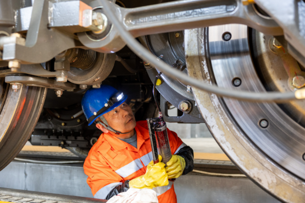 工作人员为机车轮对齿轮箱添加润滑油。 舒文彬摄