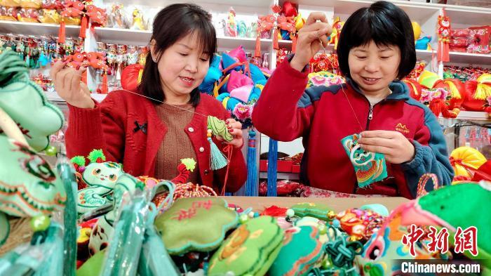 1月17日，甘肃庆阳市，绣娘们在刺绣工作室赶制新春香包。盘小美　摄