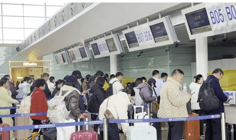 ▲在昌北机场，旅客排队办理值机手续。