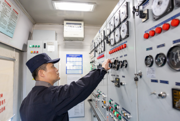 发电车乘务员正在对发电车机组仪表盘进行检查。舒文彬摄