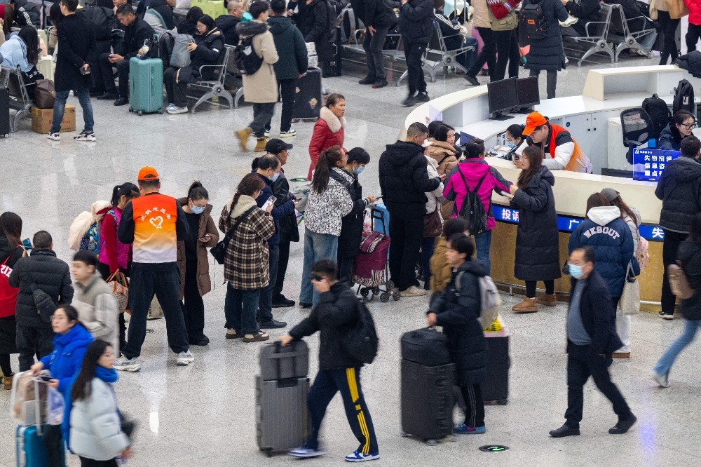 春运首日，重庆北站候车大厅里，志愿者为旅客提供现场服务。记者 崔力 尹诗语 摄